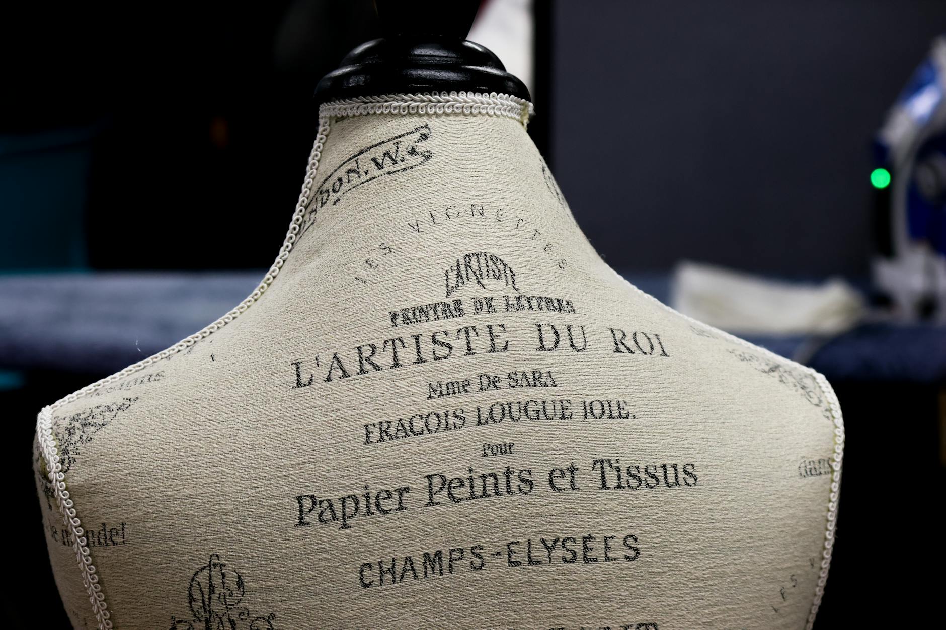 Tailor's measuring tape and needle on neatly folded formal wear.