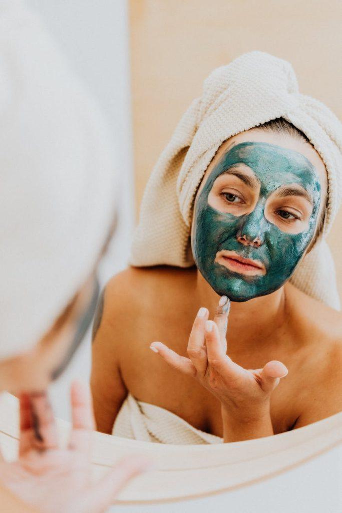 DIY spa treatments: woman applying a face mask with natural ingredients.